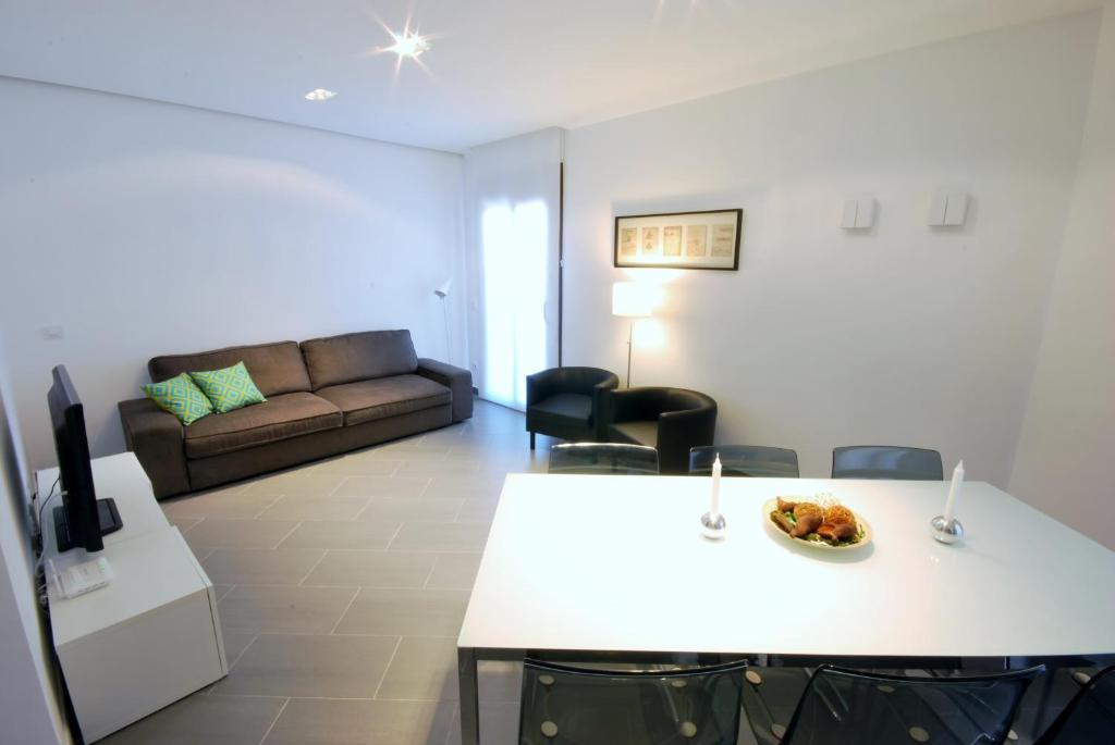 sala de estar con mesa blanca y sofá en Gran Via SDB, en Barcelona