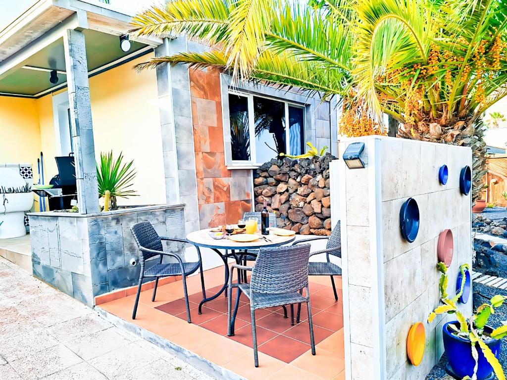 eine Terrasse mit einem Tisch und Stühlen darauf in der Unterkunft Tiny House MADORA - sea view - amazing garden - quiet location - Bodegas & hiking trails nearby in La Asomada
