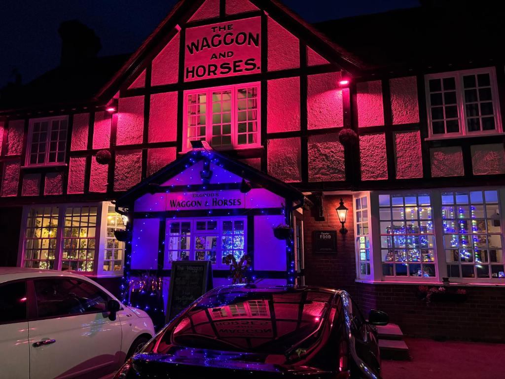 a building with purple lights in front of a house at Stylish Garden pod lodges in Milton