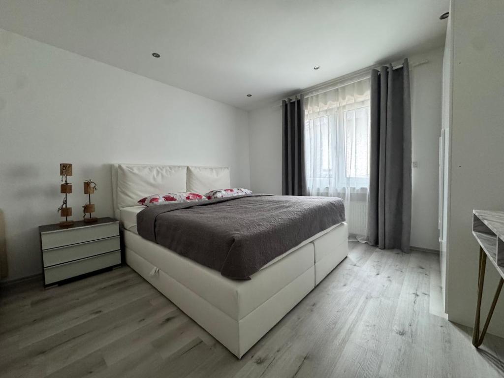 een witte slaapkamer met een groot bed en een raam bij Idyllische Wohnung mit Küche & Bad in Bielefeld in Bielefeld