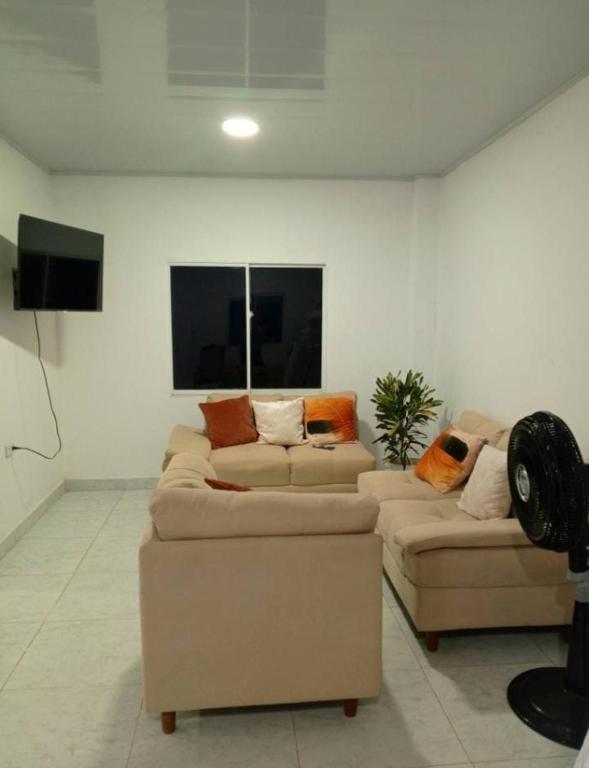 a living room with two couches and a tv at Casa Isabel in Santa Cruz de Mompox