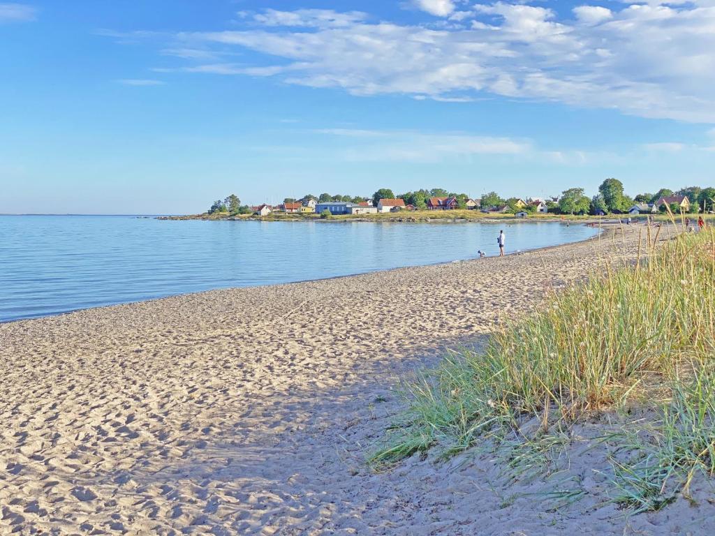 a sandy beach next to a body of water at Strandlogiet Ljugarn in Ljugarn