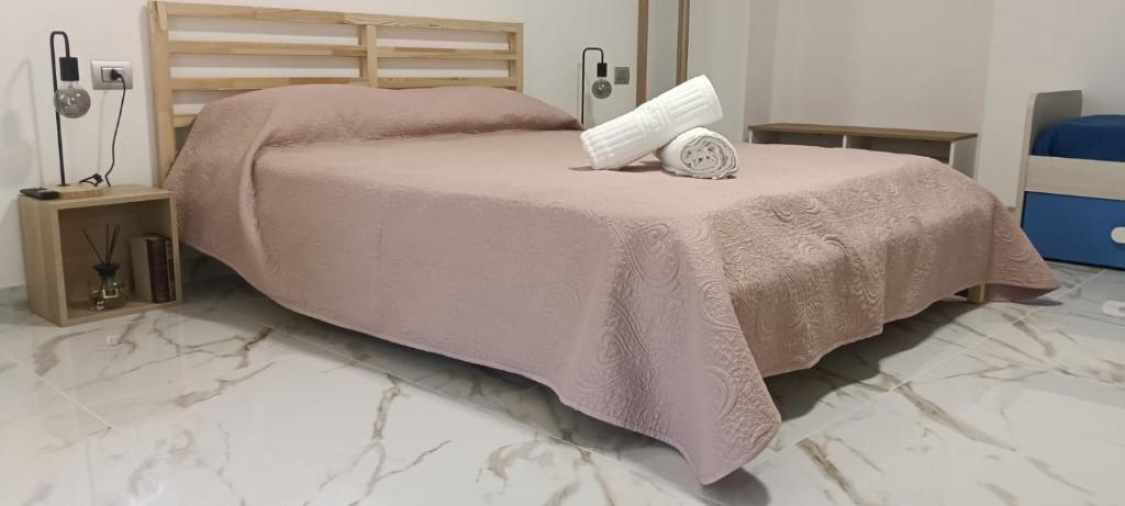 a bed with a pink blanket and a clock on it at La piazza in San Giorgio la Molara