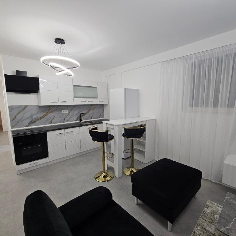 a white kitchen with two stools in a room at Lux Apartman Ilidza in Raskršće