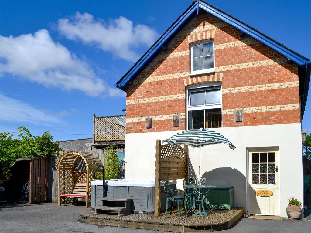 a table and an umbrella in front of a house at Myrtle Loft in Instow