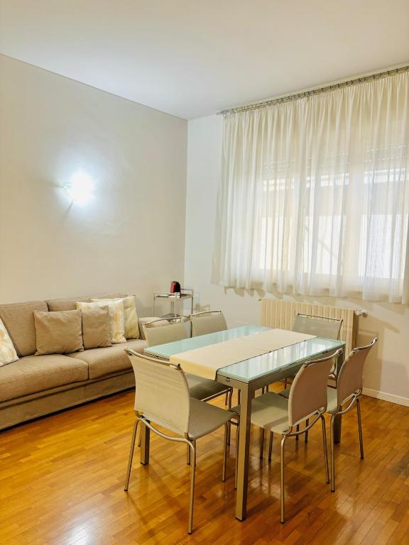 a living room with a table and chairs and a couch at Appartamento Crema centro in Crema