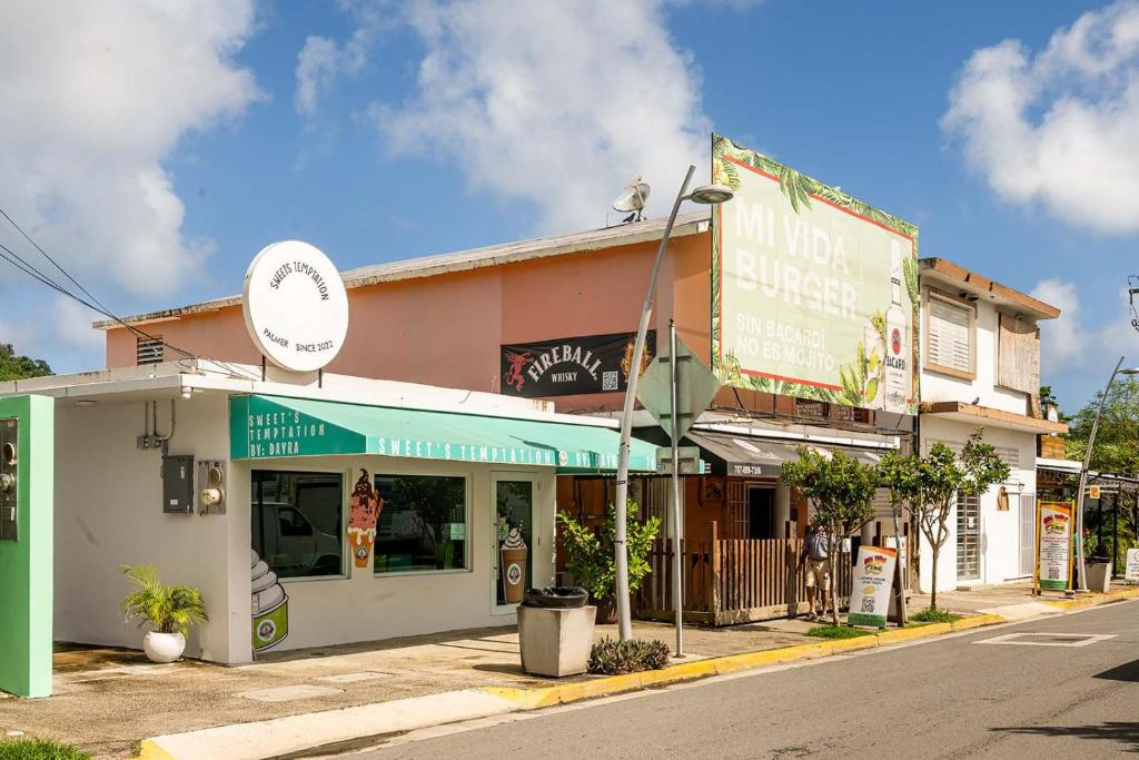 ein Gebäude an einer Straßenecke mit einem Geschäft in der Unterkunft Kyo I Rustic Villa Beach/Golf Paradise in Rio Mar in Carmelita