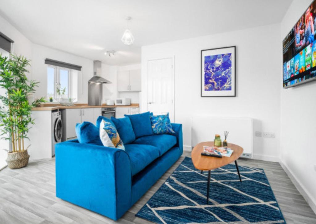 un canapé bleu dans un salon avec une table dans l'établissement 2 Bed Apartment - Parking - Sleeps 3 - Netflix 50C, à Sleightholme