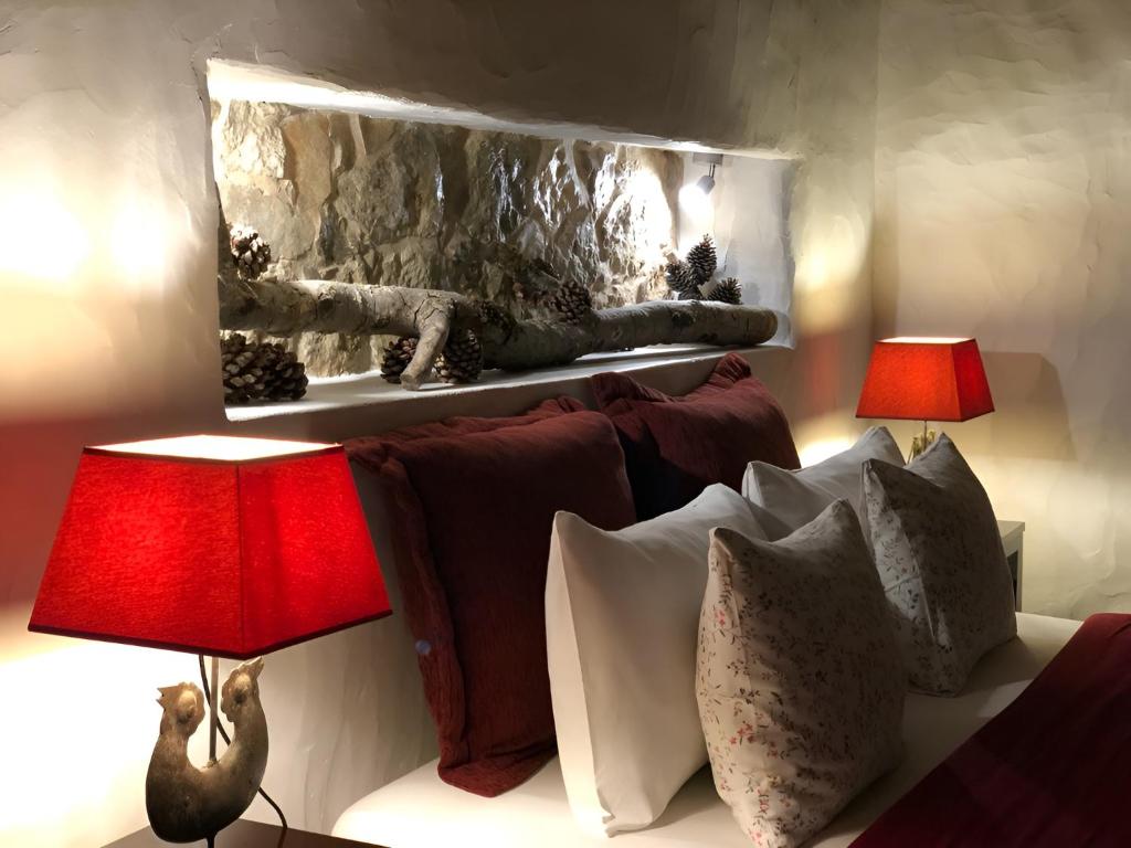 ein Wohnzimmer mit zwei Lampen und einer Couch mit Kissen in der Unterkunft Casal da Serrana in Óbidos