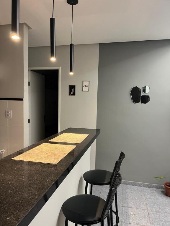 eine Küche mit zwei Stühlen und einer Theke mit Arbeitsplatte in der Unterkunft Casa aconchegante em Aracaju na Aruana in Aracaju