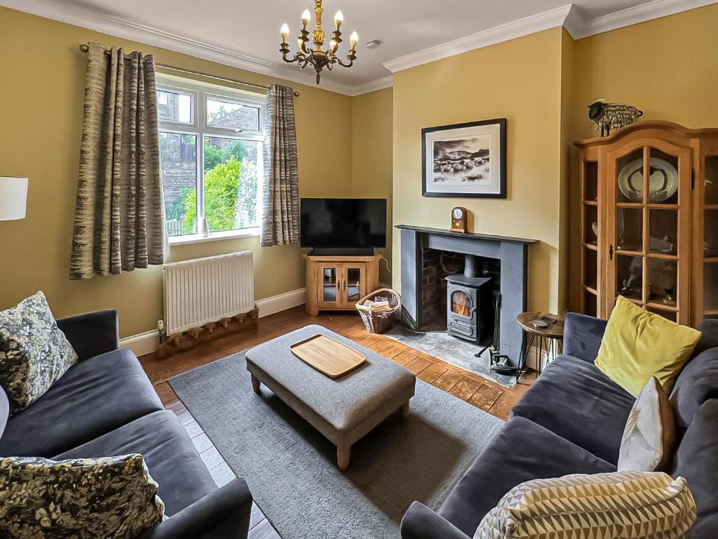 a living room with a blue couch and a fireplace at Lancashire And Yorkshire Cottage in Hellifield