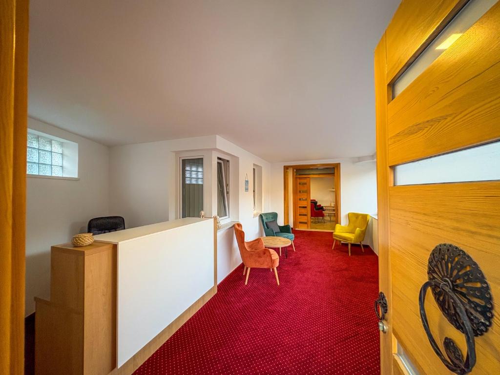 een woonkamer met een rood tapijt en een deur bij Residence Mahala - Boutique Guesthouse near Baščaršija in Sarajevo