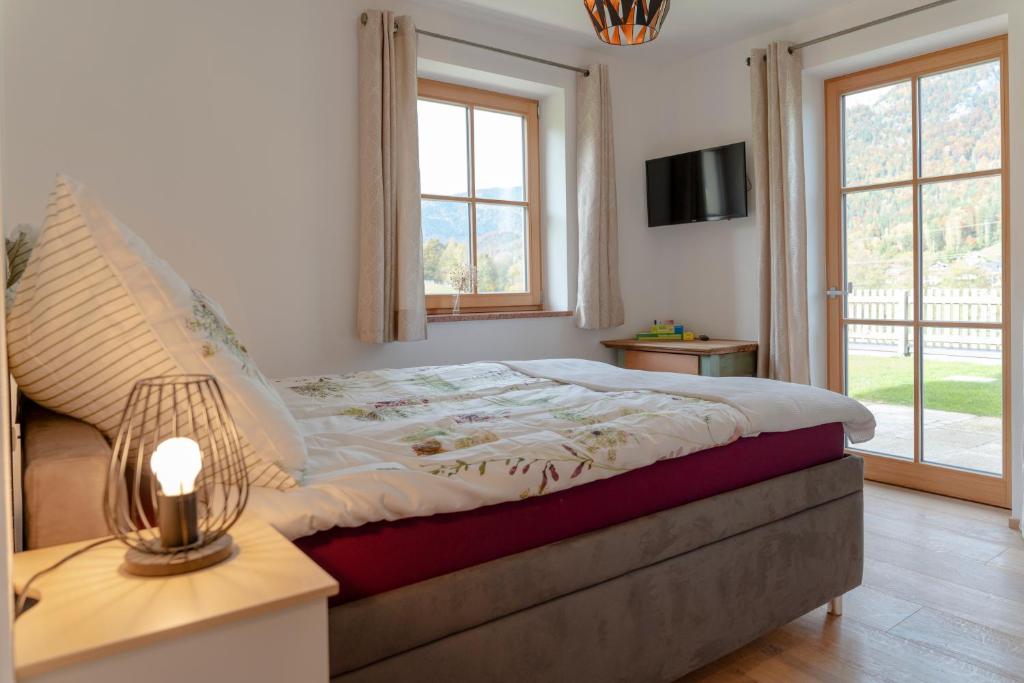 Un dormitorio con una cama con una lámpara y una ventana. en Das Nest, en St. Wolfgang