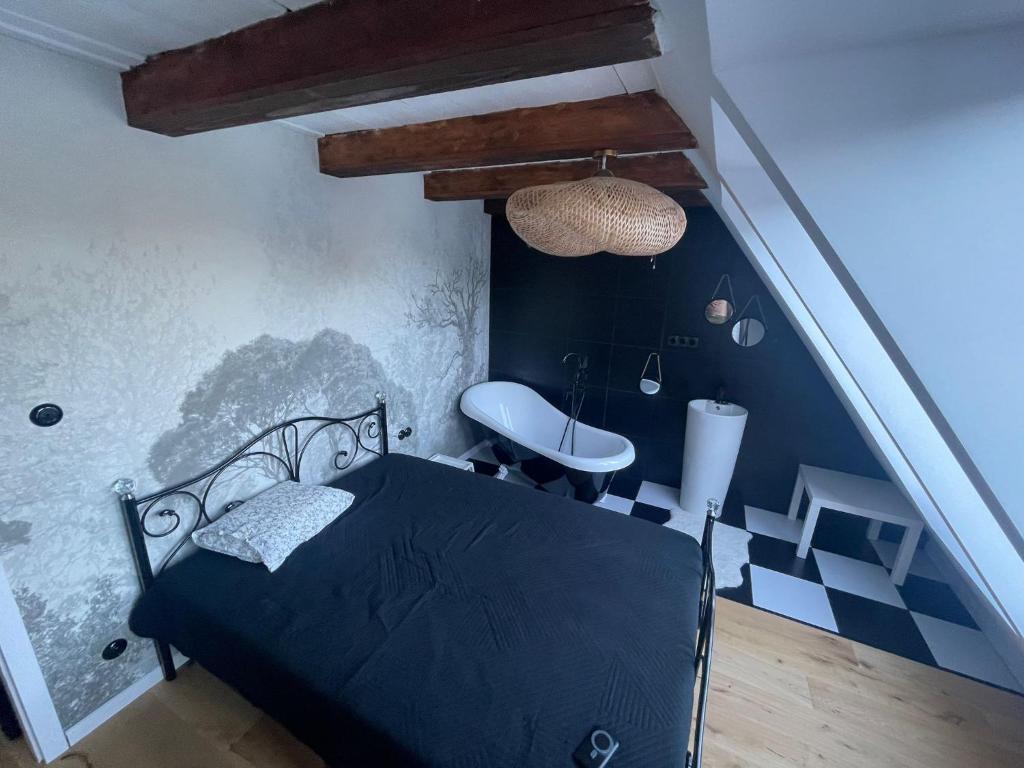 a bedroom with a black bed and a sink at Lake House by Fregata Restaurant in Zagórze Śląskie