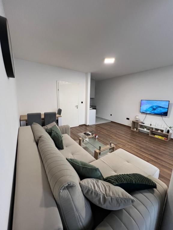 Una sala de estar con un sofá y un televisor. en TM Apartment Prijedor, en Prijedor
