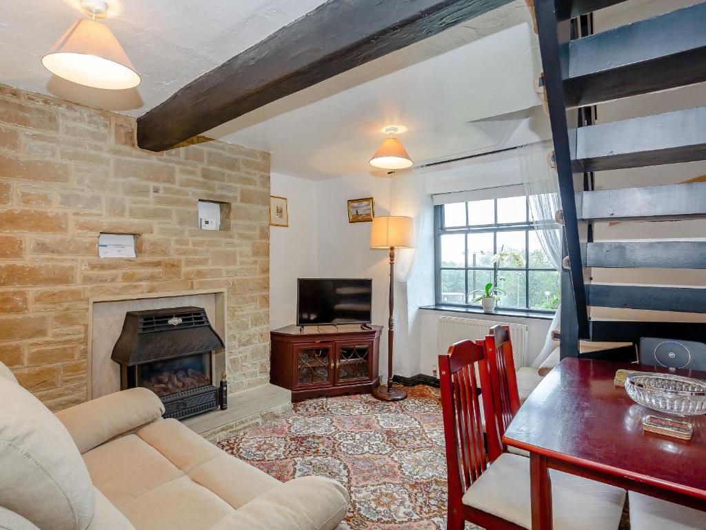 a living room with a couch and a fireplace at Ginny's Cottage in Haworth