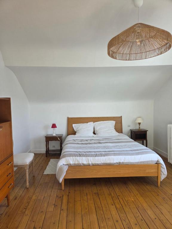 a bedroom with a large bed with a wooden floor at Le Polygone in Le Mans