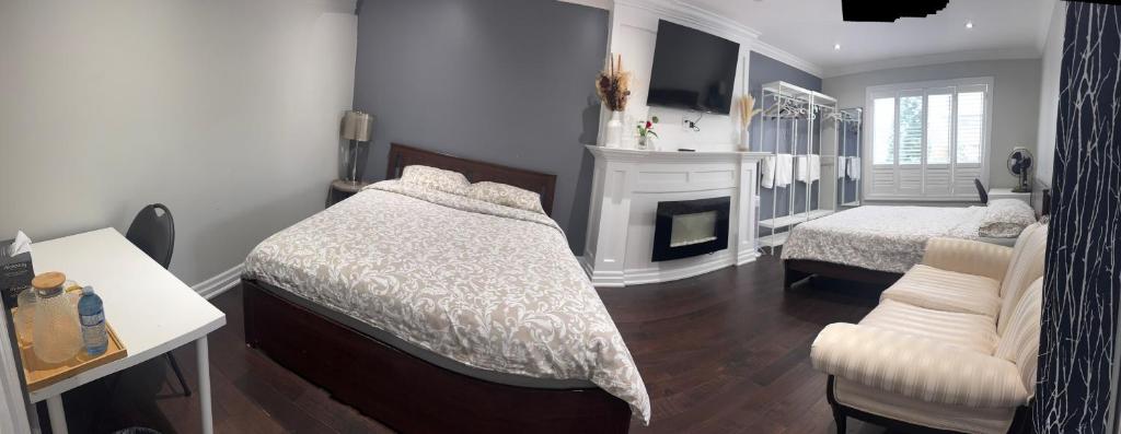 Un dormitorio con una cama y una chimenea. en F3 Spacious room with 2 queen beds and TV, en Mississauga