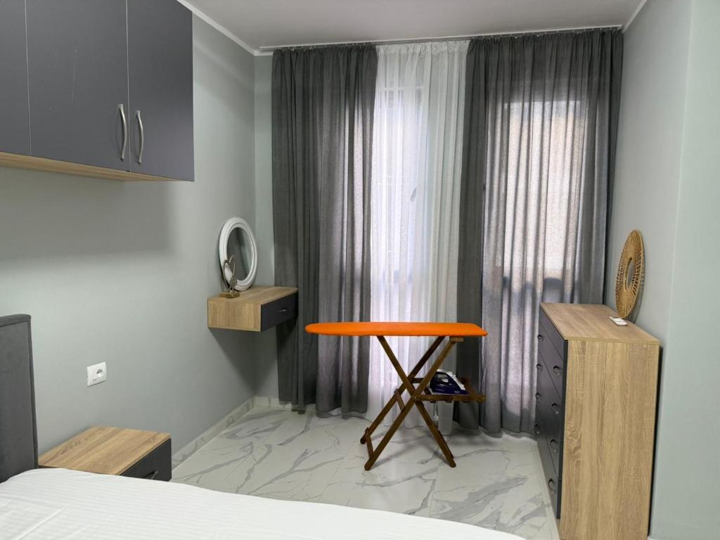 a bedroom with a bed and a table in front of a window at Luxury Apartment Orikum in Orikum