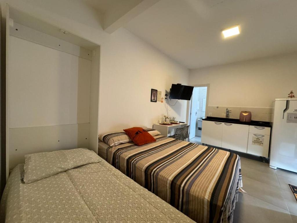 two beds in a small room with a kitchen at Apto térreo em Tijucas n 04 in Tijucas