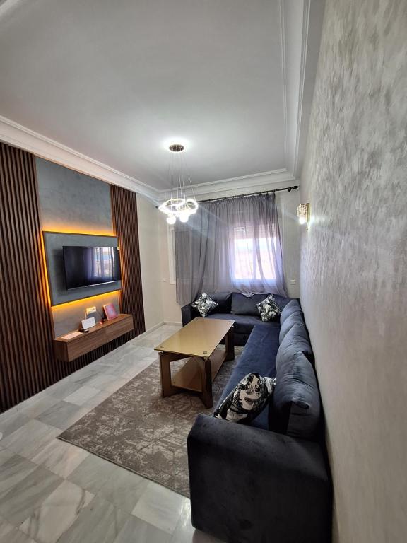 a living room with a blue couch and a table at Appartement Laaziz in Tangier