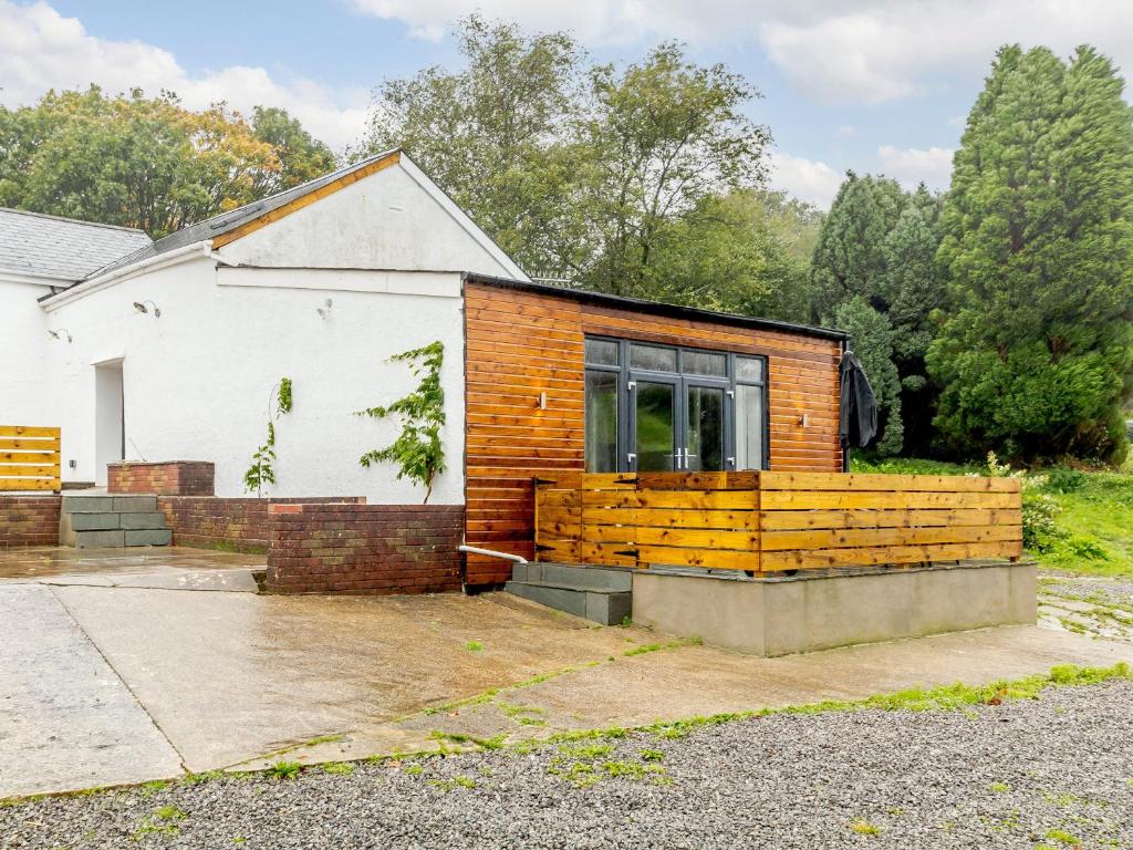 a house with a wooden fence in front of it at The Barn-Uk32860 in Alltwen