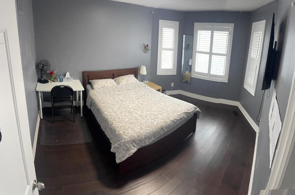 een slaapkamer met een bed en een tafel met een bureau bij Q88 luxury Sunny room in Mississauga