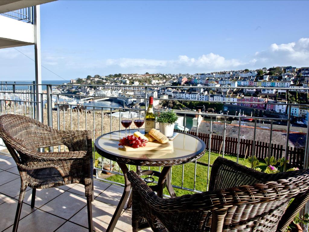 einen Tisch mit einem Glas Wein und einem Teller Essen in der Unterkunft Turnstone - 2 Linden Court in Brixham