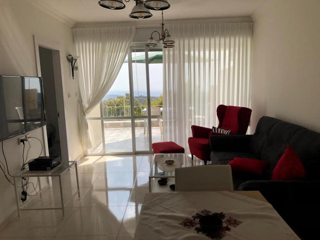 a living room with a couch and a tv at Exotic Vacation in the Jerusalem Mountains in Shoresh