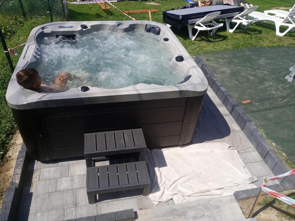 a dog laying in a hot tub in a yard at Widokowy zakątek niedaleko Energylandi Zator in Zator