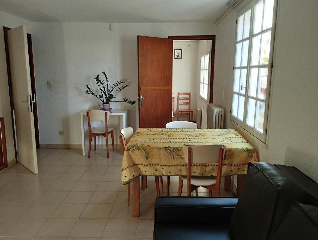 een eetkamer met een tafel en stoelen in een kamer bij L' amandier in Teyran