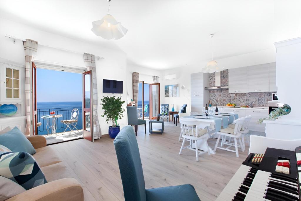 a kitchen and living room with a view of the ocean at Mare Sunset & Relax in Meta