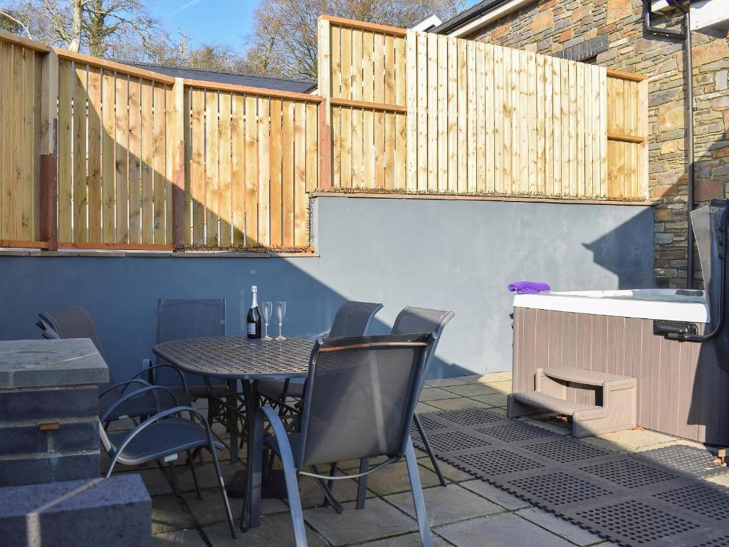a patio with a table and chairs and a sink at Stabl-Oh4 in Dihewid