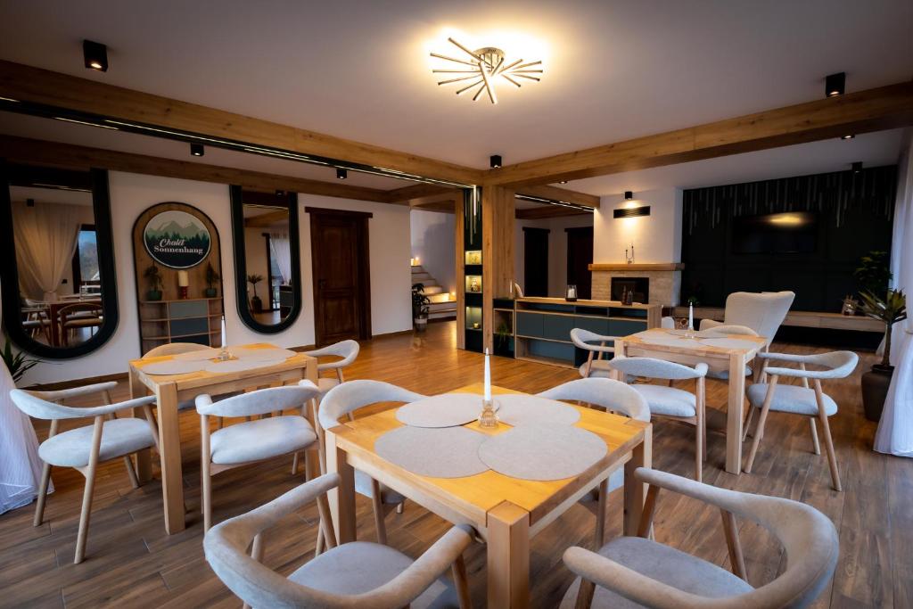 フンドゥ・モルドベイにあるChalet Sonnenhangの木製のテーブルと白い椅子のあるレストラン