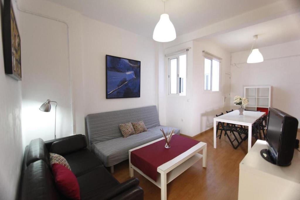 una sala de estar con un sofá y una mesa en Arce apartamentos, en Sevilla