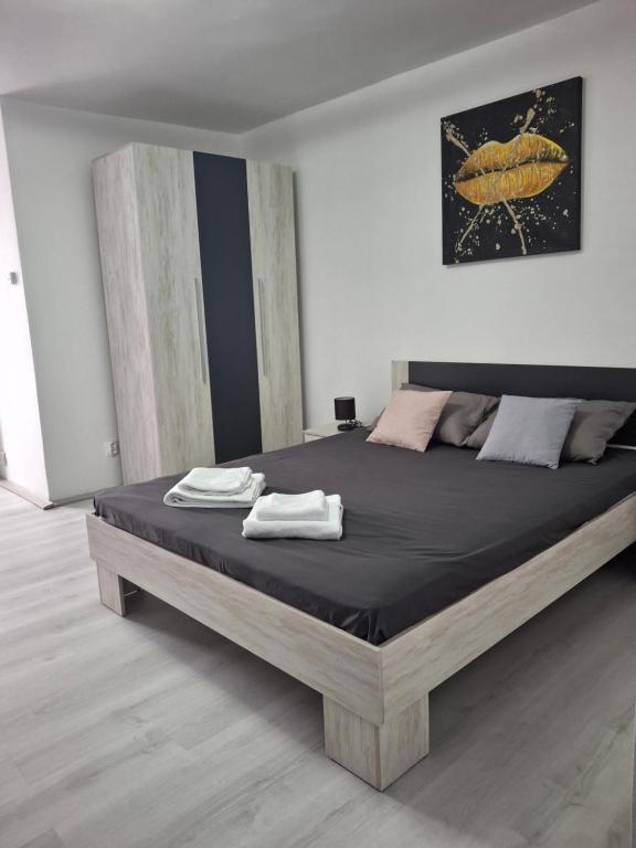 ein Schlafzimmer mit einem großen Bett mit zwei Handtüchern darauf in der Unterkunft LaCriss in Hunedoara