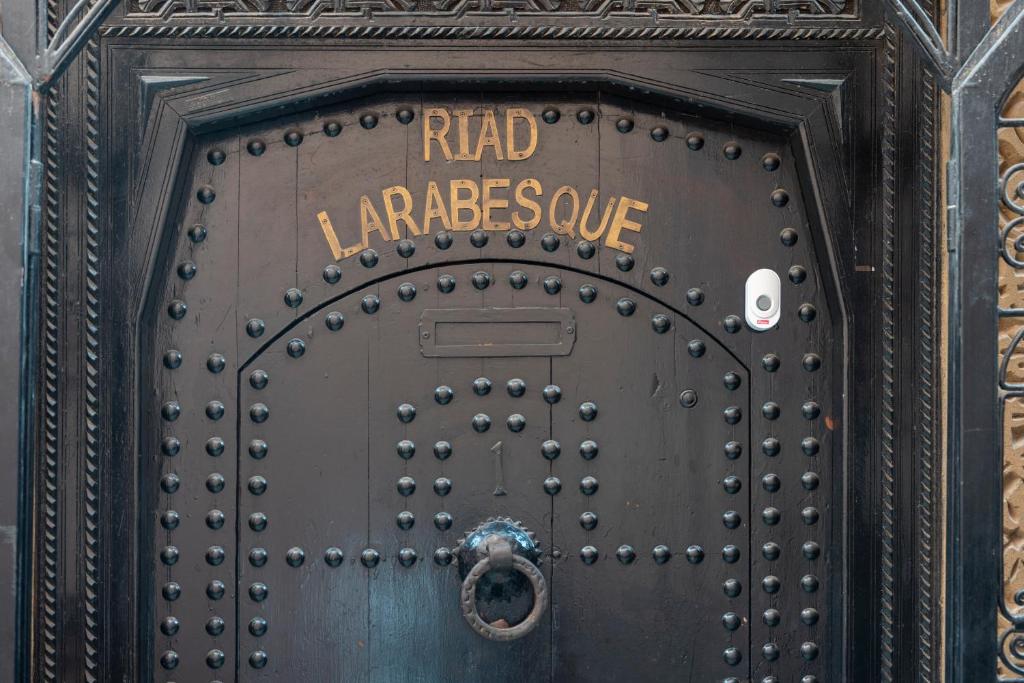 a metal door with the words raid languagescue on it at Riad Arabesque in Marrakech