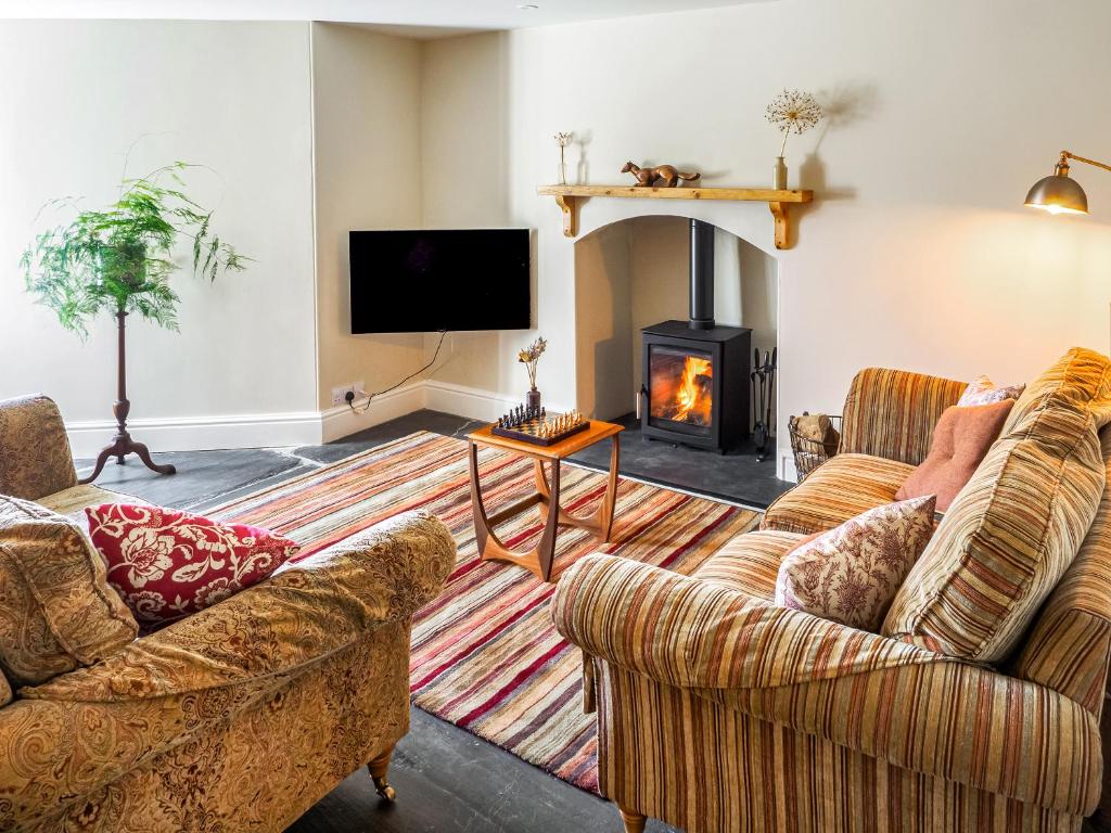 een woonkamer met twee banken en een open haard bij Hollyhock in Tavistock