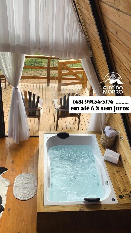 a hot tub in a room with a tent at Chalé Alto do Morro 2 - conforto e vista deslumbrante in Rancho Queimado