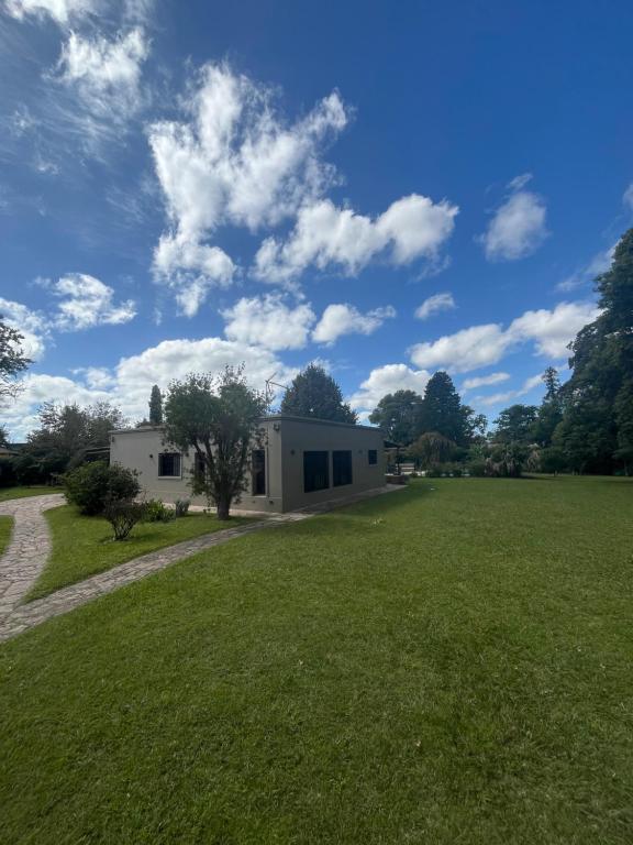 ein Haus auf einem Feld mit einem Rasenplatz in der Unterkunft Increible casa Quinta en Ing Maschwitz in Maquinista Savio