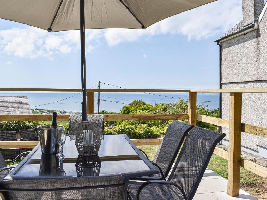a table and chairs with an umbrella on a patio at Bryn Derwen in Llanfair