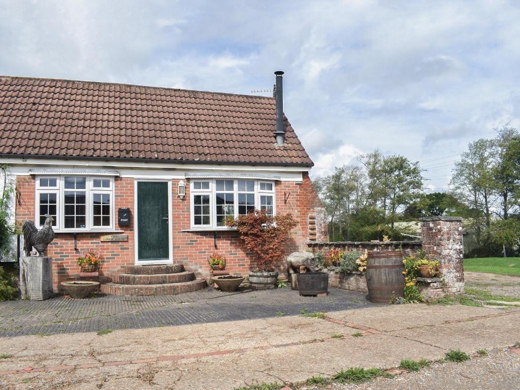 Una pequeña casa de ladrillo con flores en macetas delante de ella. en The Coach House - Uk41070, en Wootton Bridge