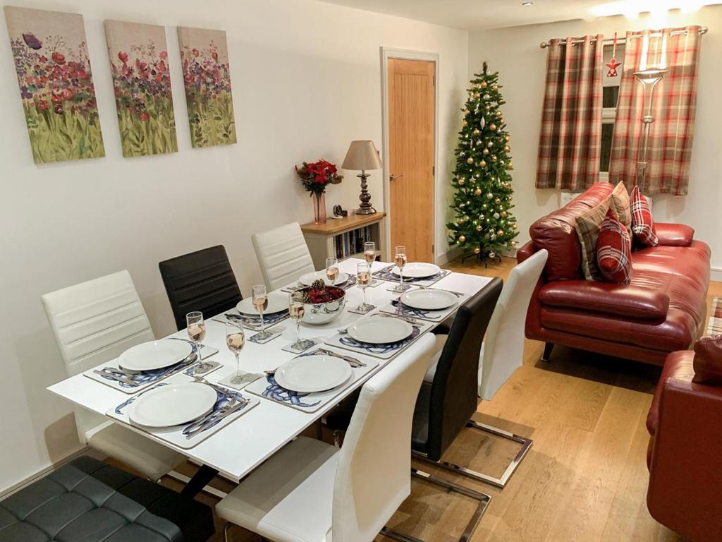 a dining room with a table and a christmas tree at Cobble Cottage - Uk38973 in Whitby