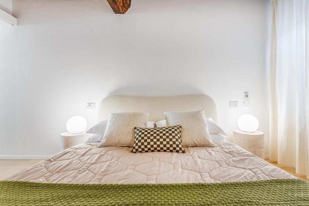 a white bedroom with a large bed with pillows at Fumo di Lambrusco - Rua Frati 34 - Boutique Apartment in Modena
