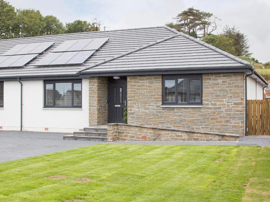 a house with solar panels on the roof at 4 Mote View-Uk37497 in Sandhead