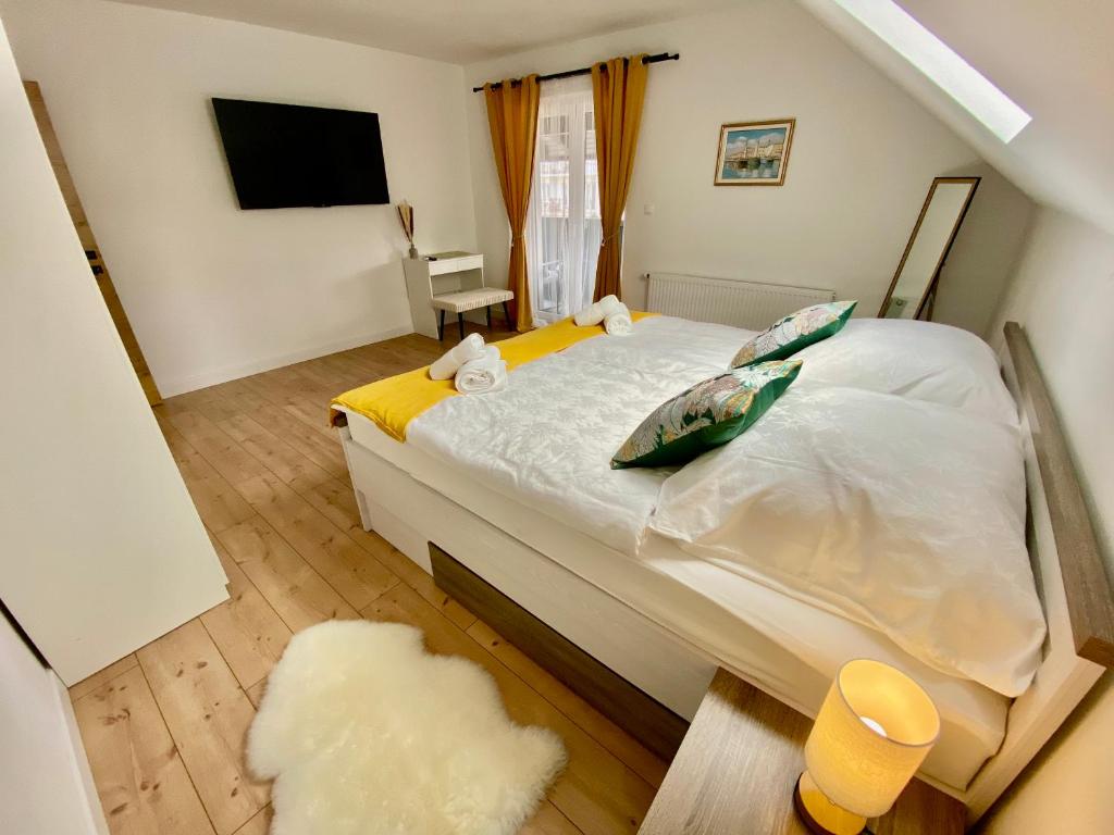 a bedroom with a large white bed with a television at Filuma Suite with private terrace and balcony PANORAMIC GACKA VIEW in Otočac