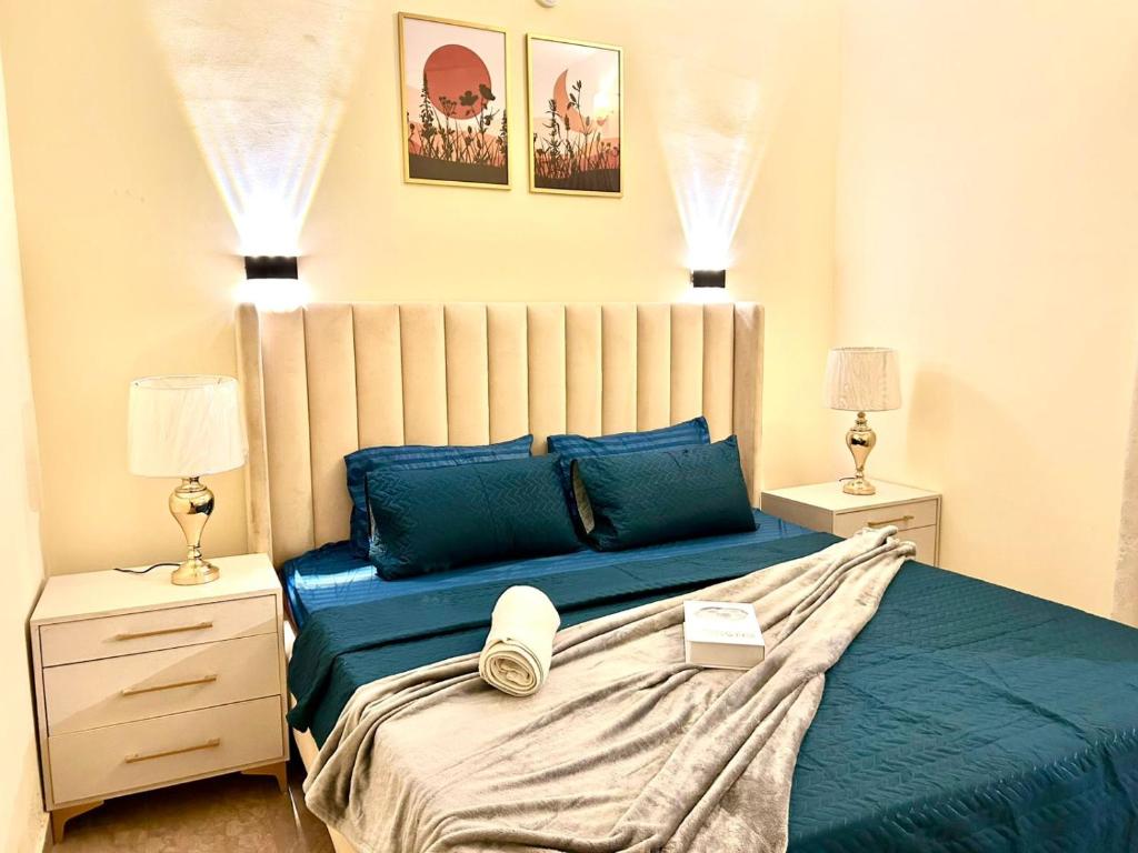 a bedroom with a bed with blue sheets and blue pillows at Heaven Four Suites in Karachi