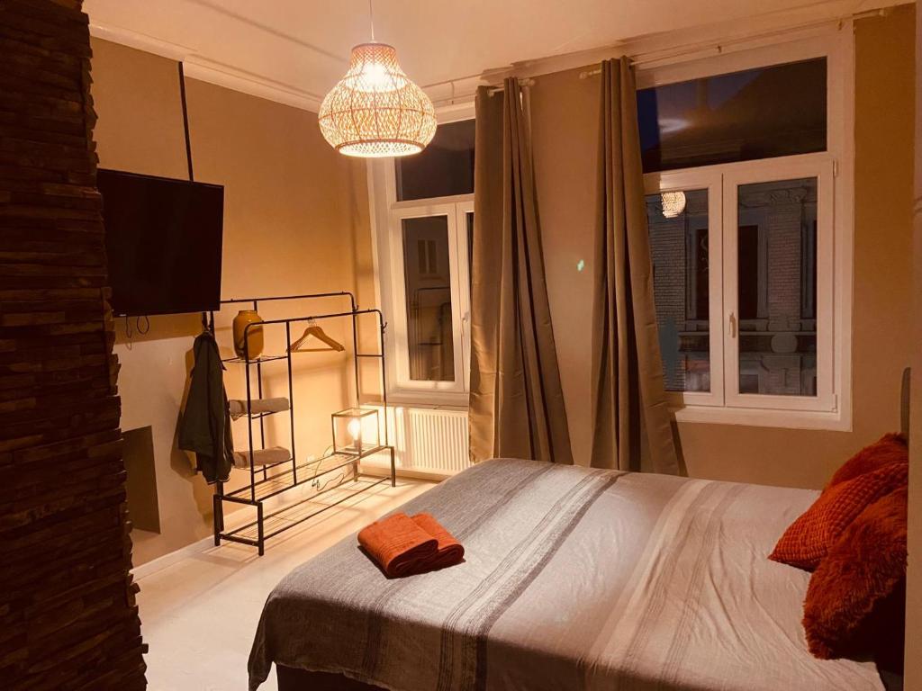 a bedroom with a bed and a chandelier at Suite Blanche in Ostend