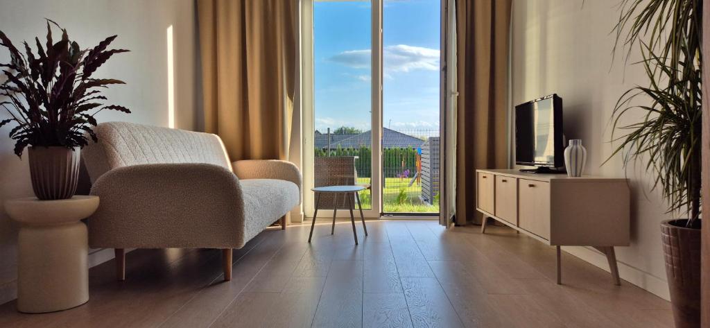 ブスコ・ズドロイにあるSłoneczny Ogródekのテレビとソファと椅子のあるリビングルーム