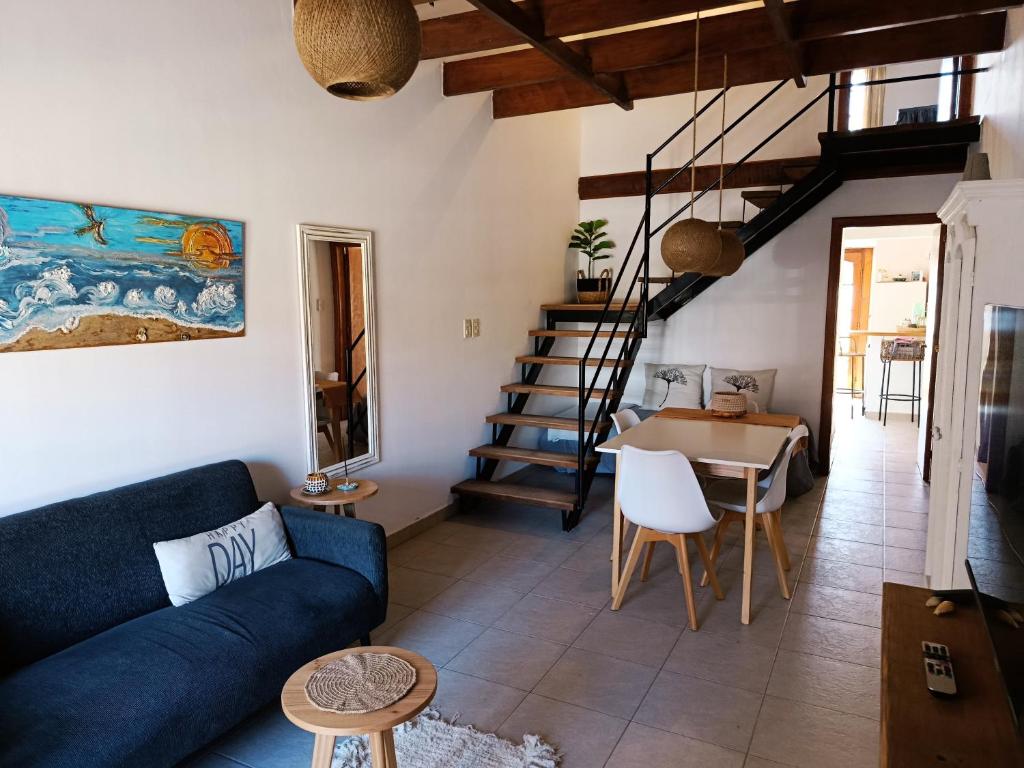 a living room with a blue couch and a table at Arena Duplex in Necochea